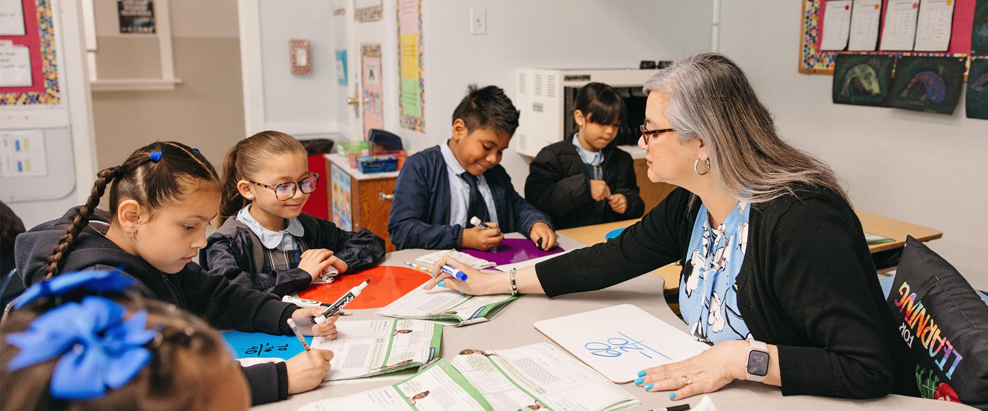 St. Raphael teacher helping students with their work