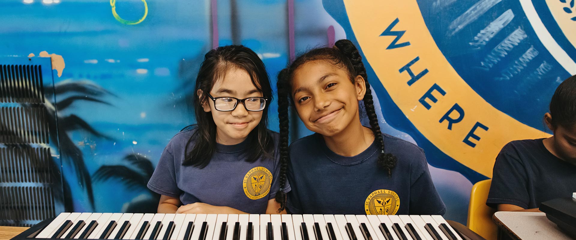 Two St. Raphael students sit together at keyboard